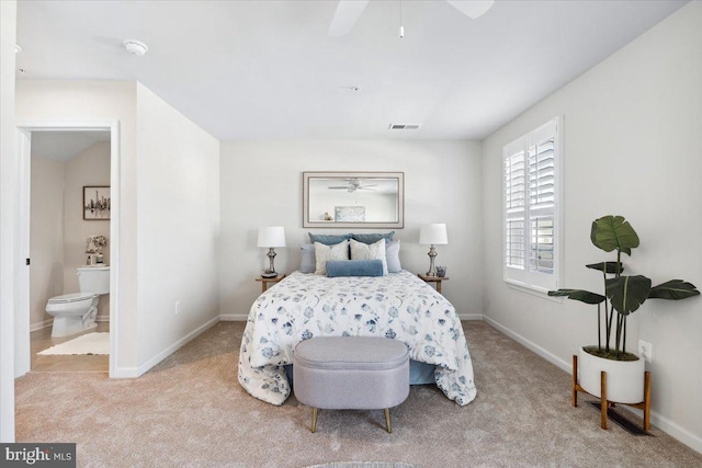 carpeted bedroom featuring baseboards, a ceiling fan, visible vents, and ensuite bath
