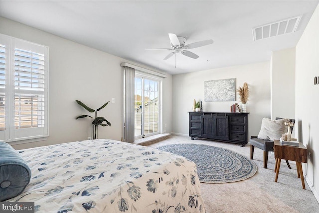carpeted bedroom with visible vents, access to exterior, and a ceiling fan