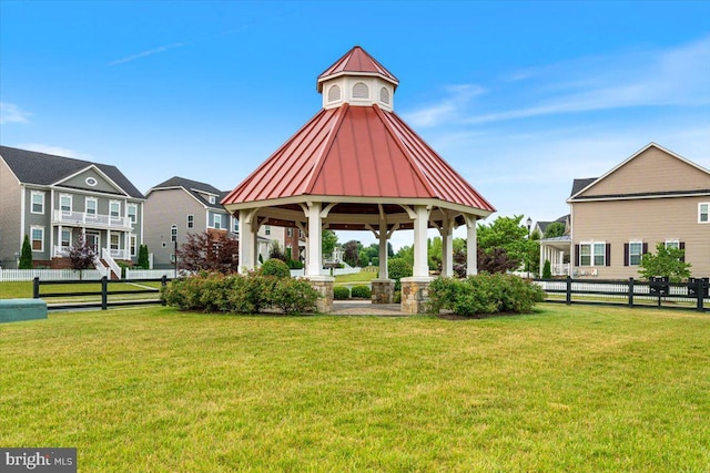 view of property's community with a gazebo, a yard, and fence