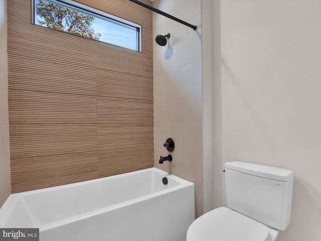 bathroom featuring tiled shower / bath and toilet