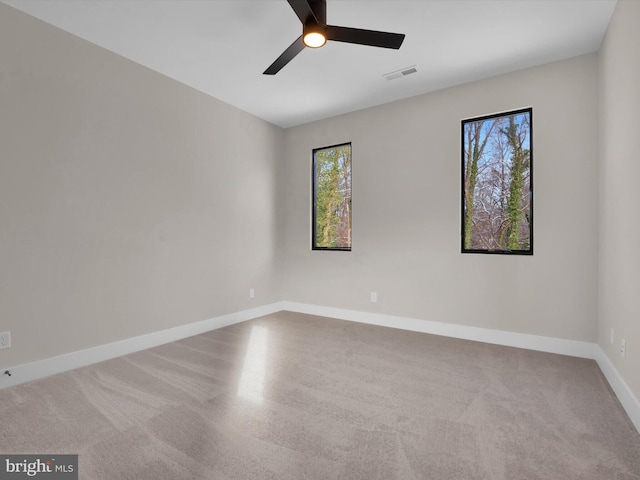 empty room featuring ceiling fan, a healthy amount of sunlight, and carpet