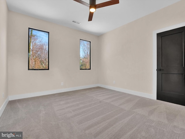 unfurnished room with ceiling fan and light carpet