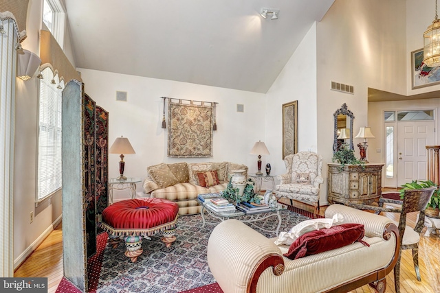 living room featuring light hardwood / wood-style flooring and high vaulted ceiling