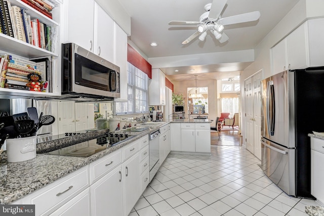 kitchen featuring white cabinetry, light tile patterned floors, light stone countertops, and appliances with stainless steel finishes