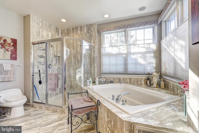 bathroom featuring separate shower and tub and toilet