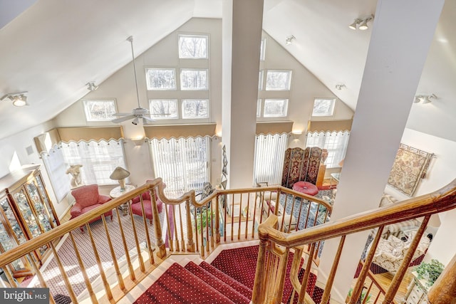 staircase with a towering ceiling and ceiling fan