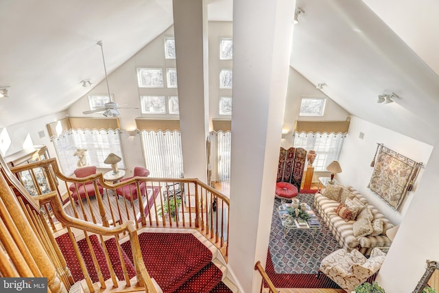 stairway with ceiling fan and high vaulted ceiling