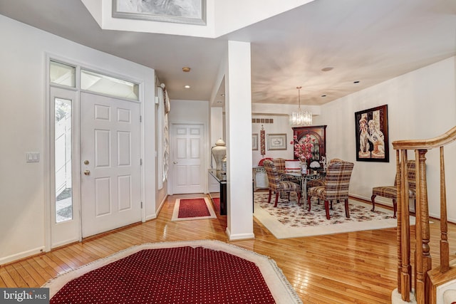 entrance foyer with hardwood / wood-style flooring and an inviting chandelier