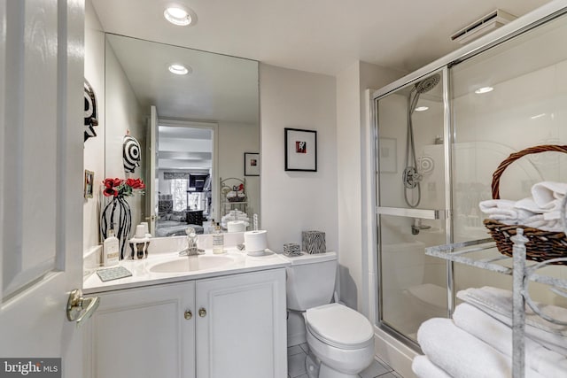 bathroom featuring tile patterned flooring, vanity, toilet, and an enclosed shower