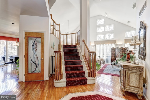 entryway featuring hardwood / wood-style floors, a towering ceiling, and a healthy amount of sunlight