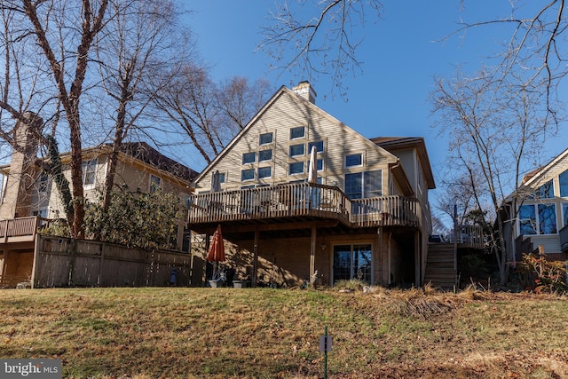 rear view of house featuring a deck and a yard