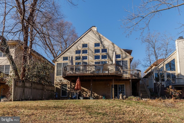 rear view of house featuring a lawn and a wooden deck