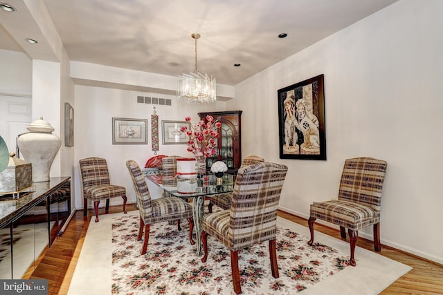 dining space with a chandelier and hardwood / wood-style flooring