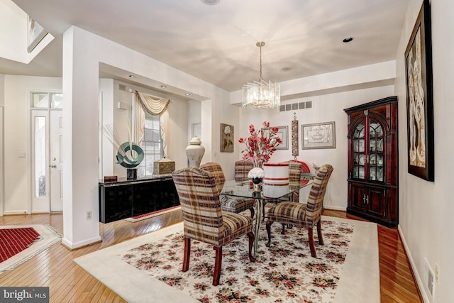 dining area featuring hardwood / wood-style floors and a notable chandelier