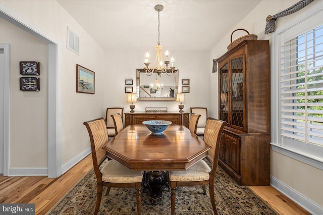 dining room with a chandelier and light hardwood / wood-style floors