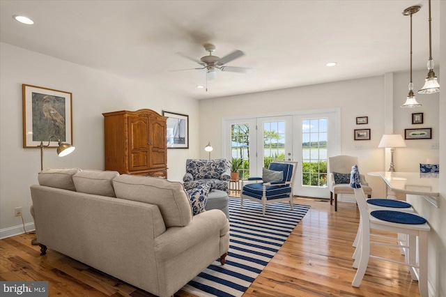 living room featuring ceiling fan, french doors, and light wood-type flooring