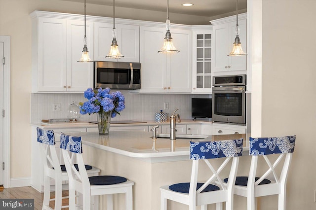 kitchen with backsplash, sink, white cabinetry, and appliances with stainless steel finishes