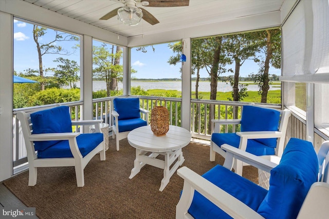 sunroom / solarium featuring a water view and ceiling fan