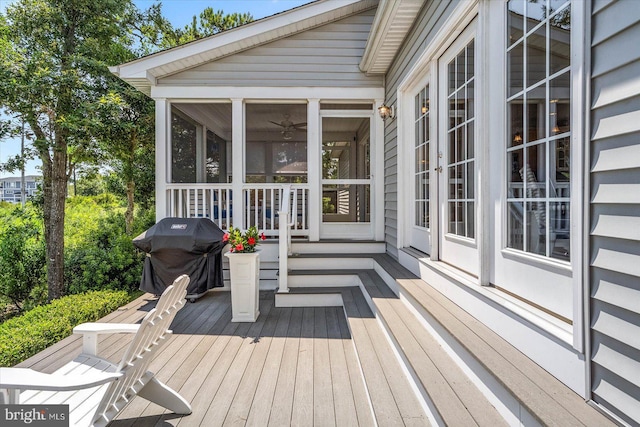 wooden terrace featuring a sunroom and area for grilling