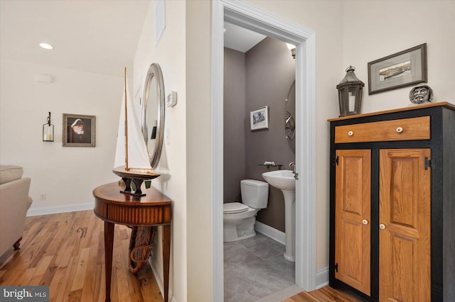 bathroom featuring hardwood / wood-style floors and toilet