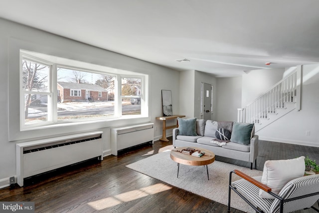 living room with dark wood-type flooring and radiator heating unit