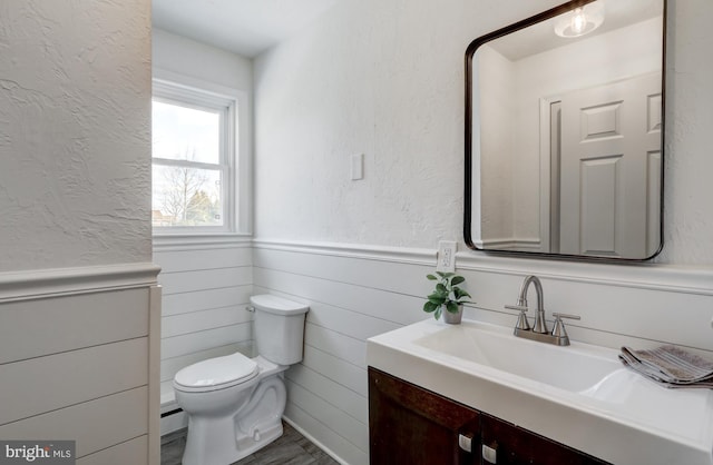 bathroom with a baseboard heating unit, vanity, and toilet