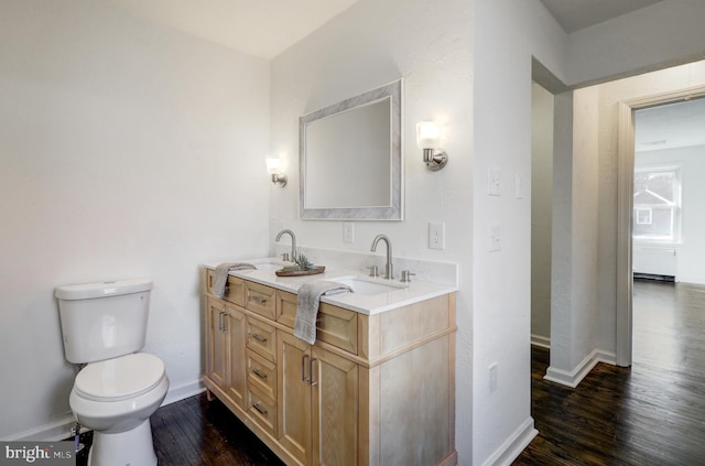 bathroom with toilet, vanity, and hardwood / wood-style floors