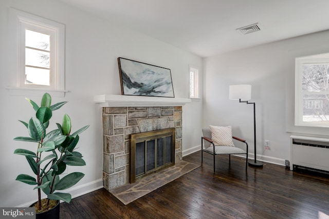 sitting room with a fireplace, radiator heating unit, and dark hardwood / wood-style floors