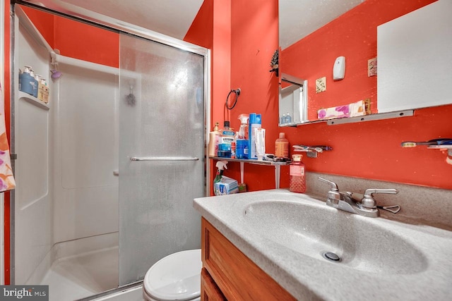 bathroom with vanity, toilet, and an enclosed shower