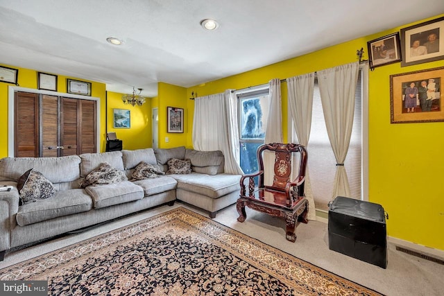 carpeted living room featuring a chandelier