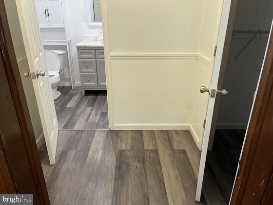 bathroom with hardwood / wood-style floors, vanity, and toilet