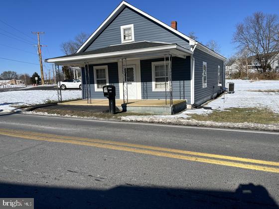 view of front facade featuring covered porch and central AC unit