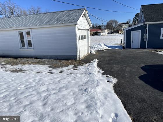 snow covered property with an outbuilding and a garage