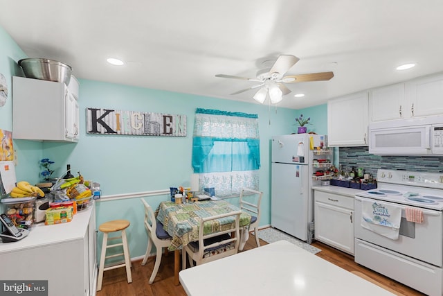 kitchen featuring hardwood / wood-style floors, white appliances, ceiling fan, white cabinets, and decorative backsplash