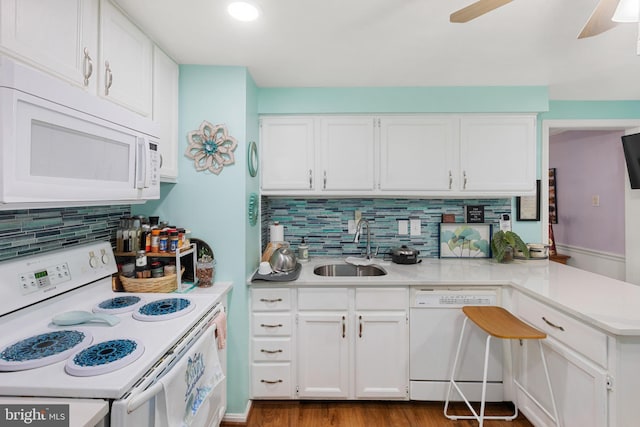 kitchen with white appliances, white cabinets, ceiling fan, sink, and kitchen peninsula