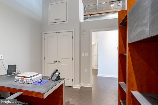 home office with a high ceiling and dark hardwood / wood-style flooring