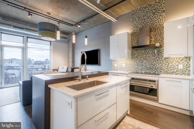 kitchen with white cabinetry, sink, stainless steel oven, wall chimney range hood, and black electric cooktop