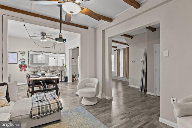 living room featuring beamed ceiling, hardwood / wood-style floors, and ceiling fan