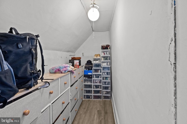 walk in closet with hardwood / wood-style flooring and vaulted ceiling