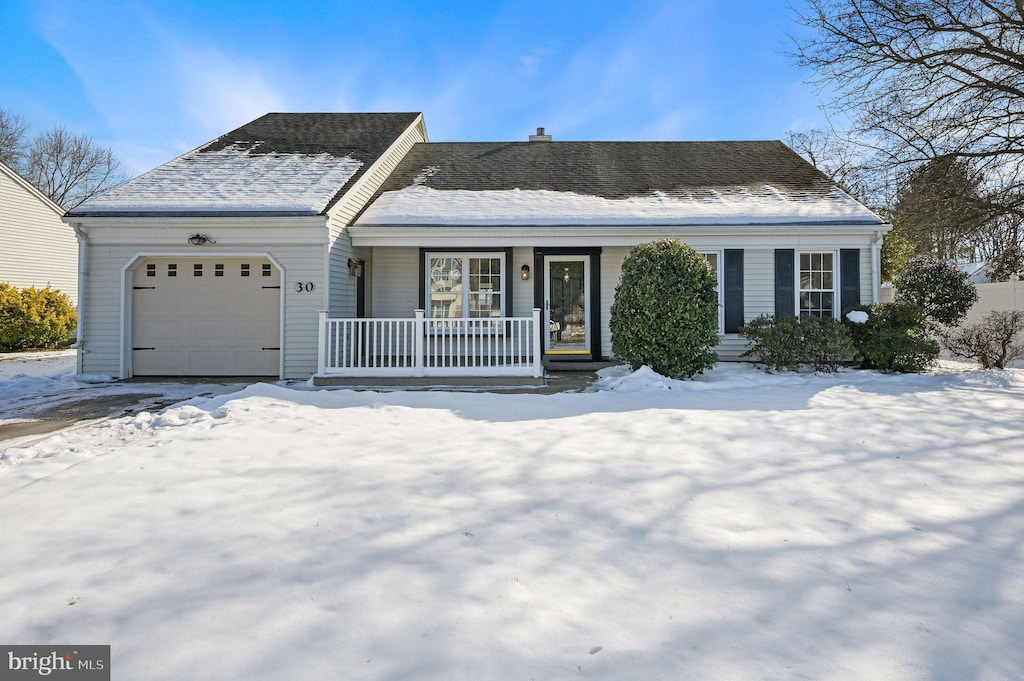 ranch-style house with a porch and a garage