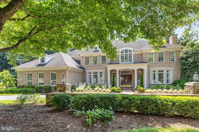 view of front of property featuring a shingled roof and brick siding