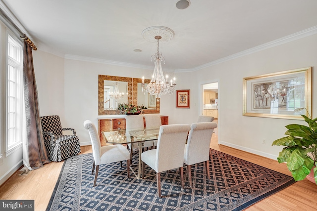 dining room featuring a chandelier, wood finished floors, and ornamental molding