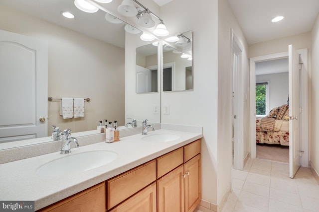 ensuite bathroom featuring double vanity, tile patterned flooring, a sink, and ensuite bathroom