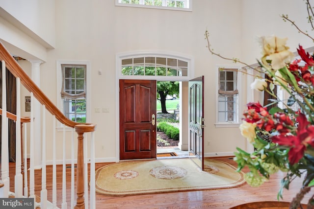 entryway with stairs, a high ceiling, and baseboards