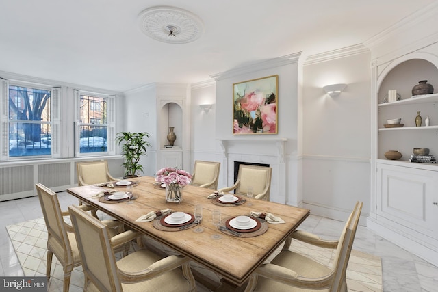 dining area featuring a high end fireplace, built in features, and crown molding