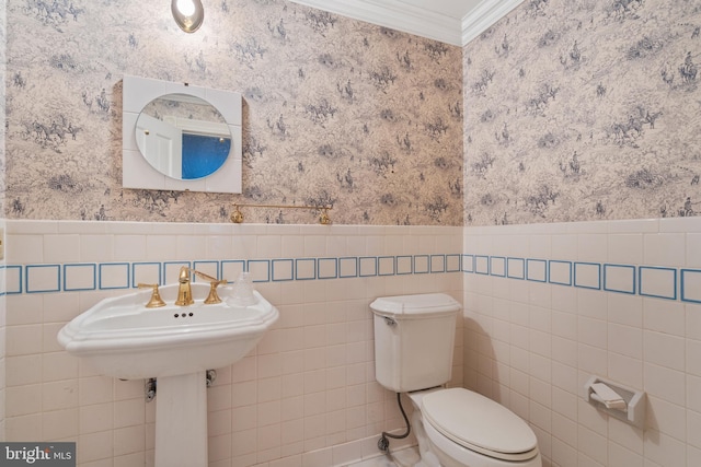 bathroom with tile walls, toilet, and ornamental molding