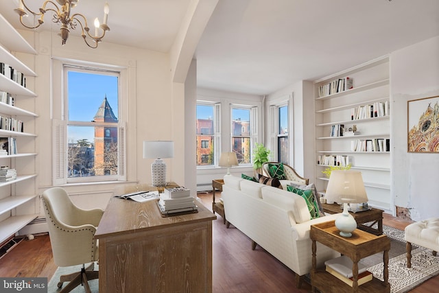 sitting room with built in features, dark wood-type flooring, a chandelier, and baseboard heating