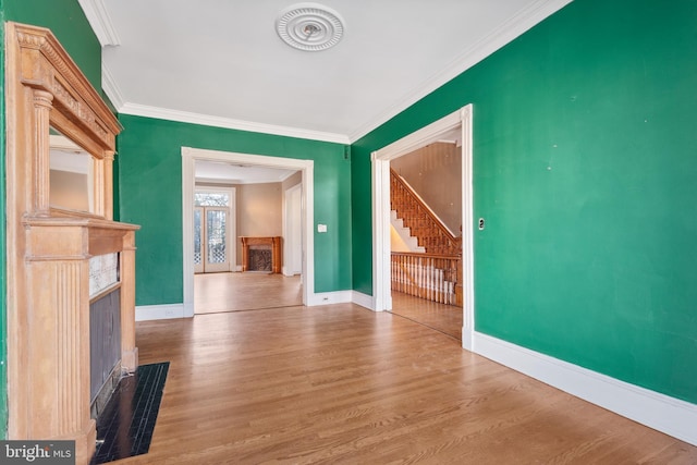 unfurnished living room featuring ornamental molding, hardwood / wood-style floors, and a premium fireplace