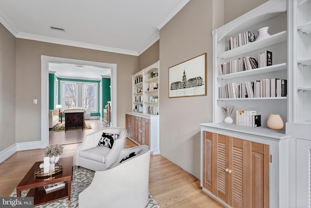 interior space featuring light wood-type flooring, built in shelves, and crown molding