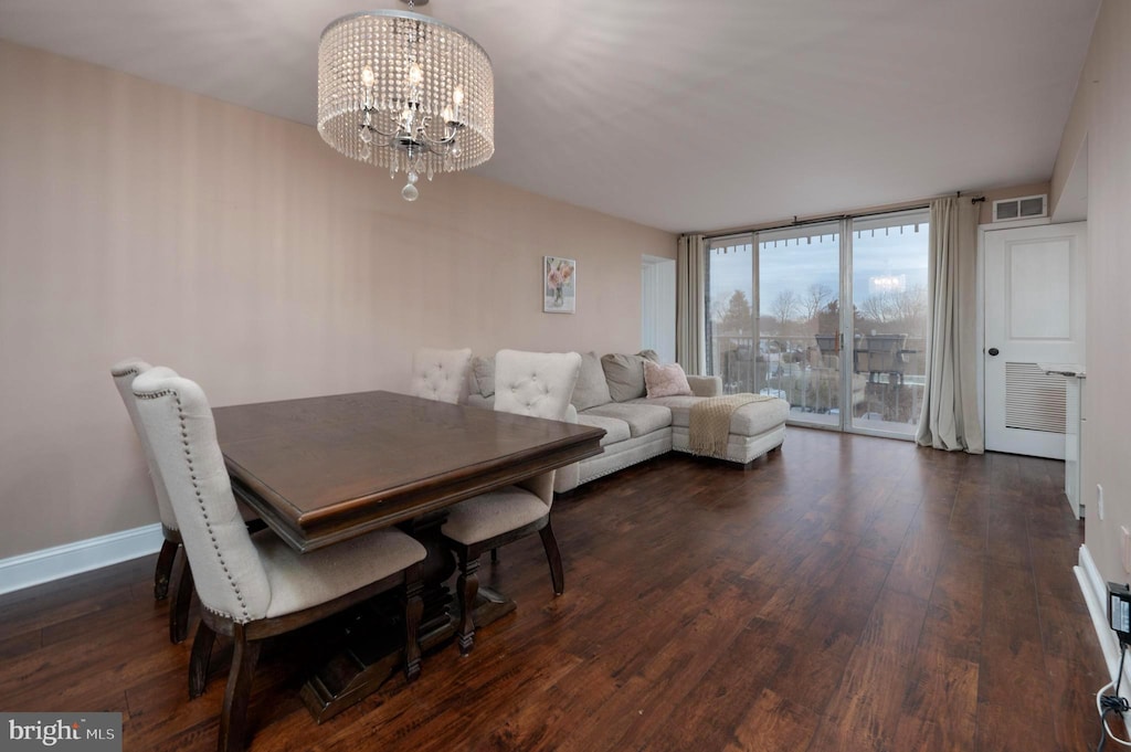 dining area with an inviting chandelier, expansive windows, and dark wood-type flooring